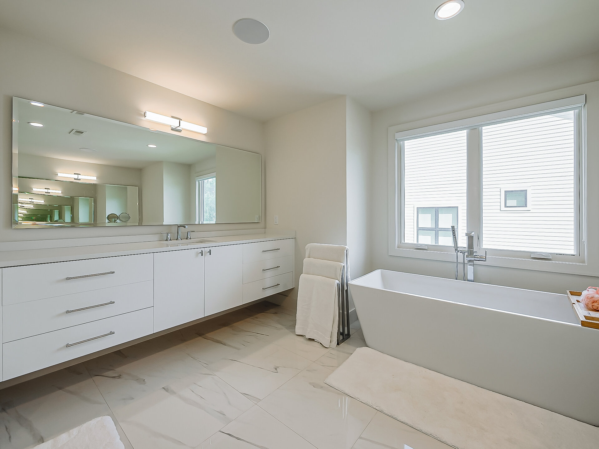Primary bathroom overview with vanity and tub