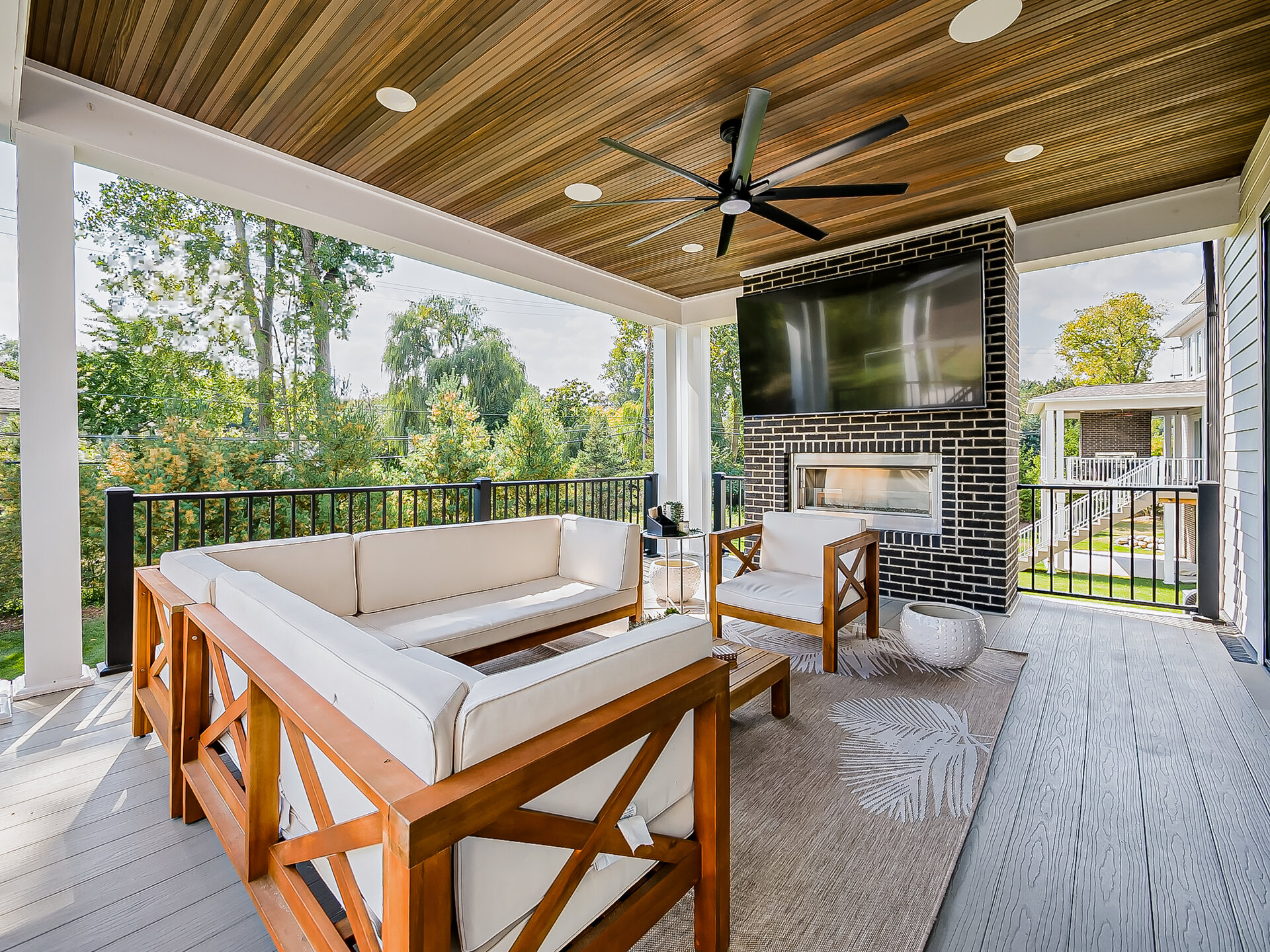 Covered patio with outdoor fireplace and TV